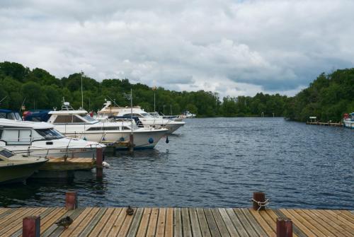 a group of boats docked at a dock on a lake at Castle Archdale Holiday Park in Enniskillen