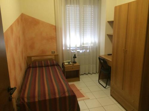- une petite chambre avec un lit et un bureau dans l'établissement Albergo Cristallo, à Cittiglio