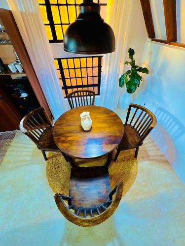 a wooden table with four chairs and a lamp at Sereno Cabana in Arusha