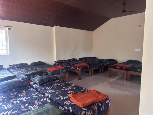 a room with four beds in a room with a window at Immanamane Homestay in Chikmagalūr