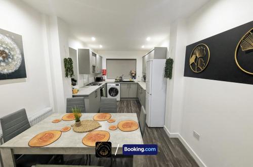 a kitchen with a dining table and a kitchen with a refrigerator at Modern 4-Bed House, Free Parking & WiFi in Swinton in Manchester