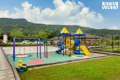a playground in a park with a slide at StayVista's Ashwamedha Manor - Mountain-Side Luxury Retreat with Outdoor Pool, Jacuzzi, Spa & Steam Room, and Indoor Activities in Karjat