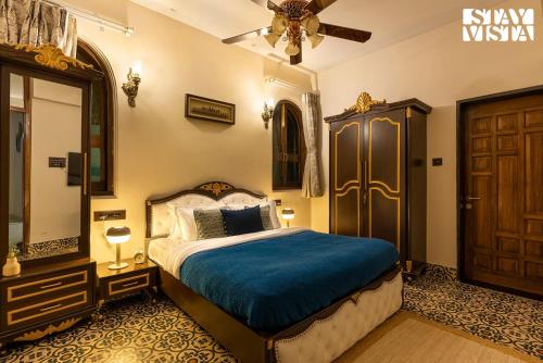 a bedroom with a bed and a ceiling fan at StayVista's Ashwamedha Manor - Mountain-Side Luxury Retreat with Outdoor Pool, Jacuzzi, Spa & Steam Room, and Indoor Activities in Karjat