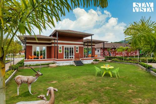 a house with a fake deer in front of it at StayVista's Ashwamedha Manor - Mountain-Side Luxury Retreat with Outdoor Pool, Jacuzzi, Spa & Steam Room, and Indoor Activities in Karjat