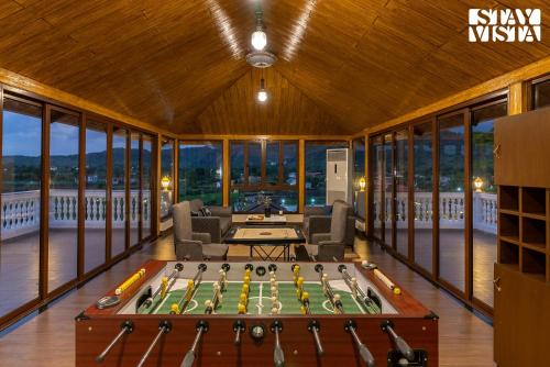 a large room with a pool table in the middle at StayVista's Ashwamedha Manor - Mountain-Side Luxury Retreat with Outdoor Pool, Jacuzzi, Spa & Steam Room, and Indoor Activities in Karjat