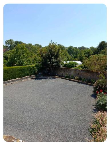 a gravel driveway with a garden in the background at Logement cosy parking privé situé au cœur du village in Reviers