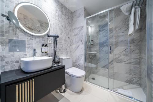 a bathroom with a sink and a shower and a toilet at Abba San Sebastián Hotel in Donostia-San Sebastián