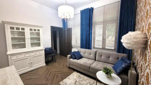 a living room with a couch and blue curtains at APARTAMENT JARACZA 28 Nr 3 in Słupsk