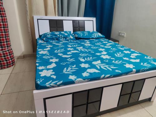a bed with a blue and white comforter at Ratnaparkhi's Villa in Dapoli