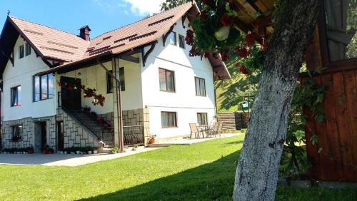 a large white house with a red roof at Casa Adi in Moieciu de Sus