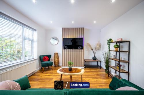 a living room with a green couch and a table at Cosy 3-Bed House l Garden l Free Parking l Stretford l Sleeps 7 l Book today with The Cosy Corner Nationwide in Manchester
