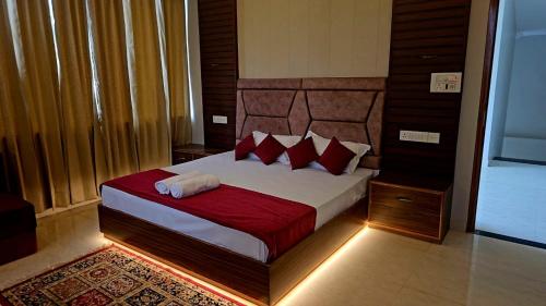 a bedroom with a large bed with red pillows at R Narayan pleasant Inn hotel in Gupta Kāshi