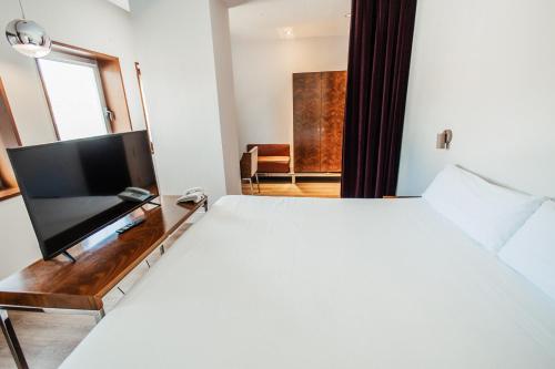 a bedroom with a bed and a flat screen tv at Palacio Avenida in Palma de Mallorca