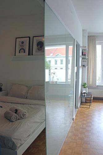 a living room with a bed and a glass wall at Sunny Apartment - Zuid Retreat 1BR Apartment near Scheldt River in Antwerp