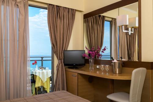 Televízia a/alebo spoločenská miestnosť v ubytovaní Manousos City Hotel