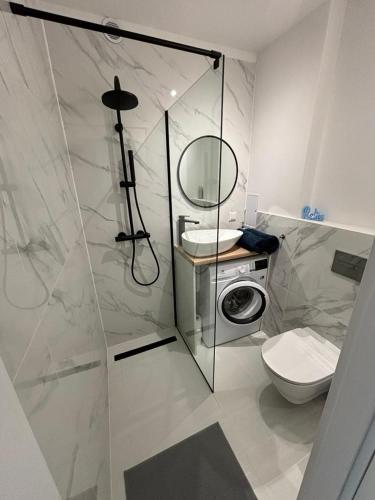 a bathroom with a shower and a toilet and a sink at A&P Studio in Gdynia
