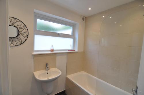a bathroom with a sink and a tub and a window at Exeter Quay & City Centre St Leonards in Exeter