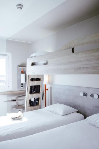 two beds in a bedroom with white walls at ibis Budget Luxembourg Aeroport in Luxembourg