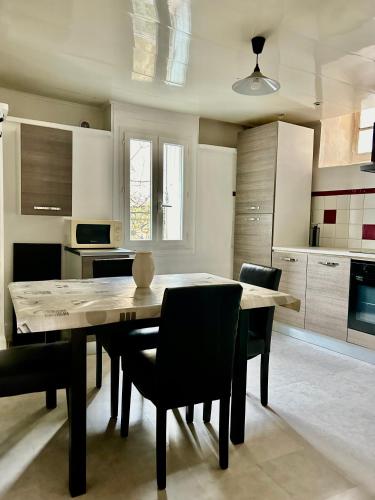 - une cuisine avec une table à manger et des chaises dans l'établissement Charmant 2 pièces centre historique Béziers, à Béziers