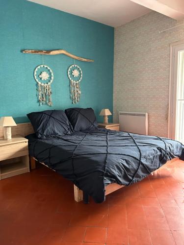 une chambre avec un lit avec un mur bleu dans l'établissement Charmant 2 pièces centre historique Béziers, à Béziers