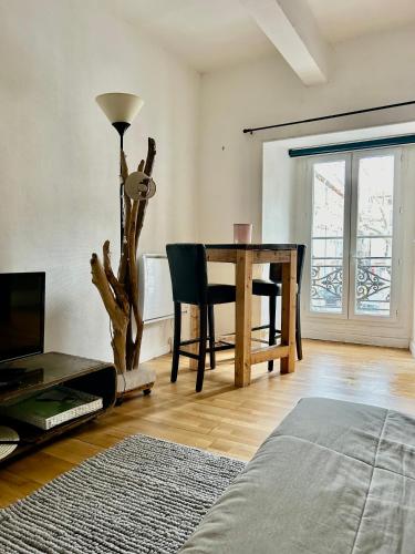 un salon avec une table et une salle à manger dans l'établissement Charmant 2 pièces centre historique Béziers, à Béziers
