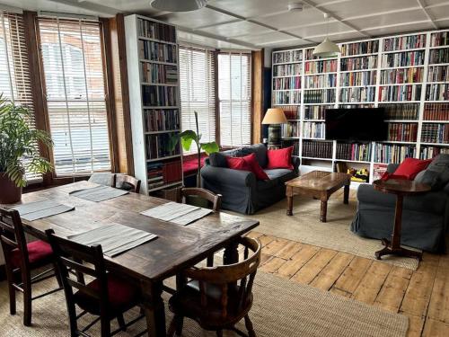 a living room with a table and a couch and book shelves at Hanushka in Hastings