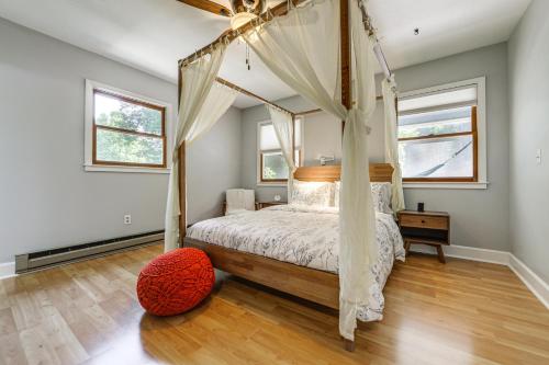 una camera con letto a baldacchino e pavimento in legno di Creek View and Hot Tub Woodsy Maggie Valley Cottage a Maggie Valley