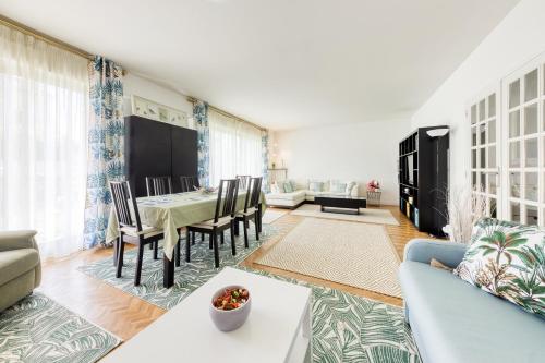ein Wohnzimmer mit Tisch und Stühlen in der Unterkunft Disponible - 5mn Paris - Gare à Pied - Jardin Terrasse - 6 pers - Centre Ville - Proche tous Commerces et transports - Wifi in Maisons-Alfort