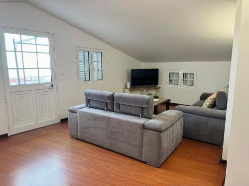 Una sala de estar con dos sofás y un televisor. en Arco Apartment, en Arco da Calheta