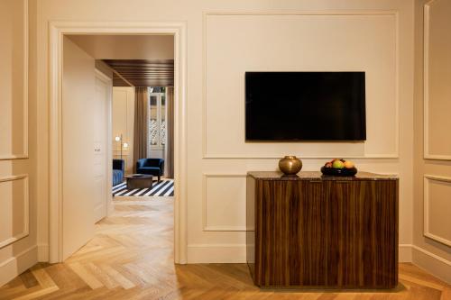 a living room with a television on a wall at The First Arte - Preferred Hotels & Resorts in Rome