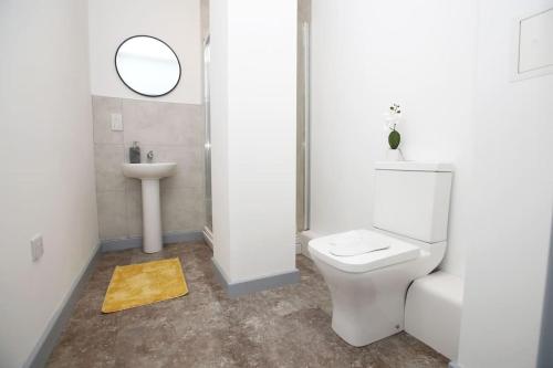 a bathroom with a white toilet and a sink at High Point 1 Bedroom Apartment in Bradford