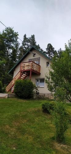 a house with a deck on the side of it at Apartmán u lesa u Adršpachu in Jívka