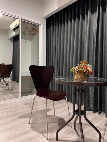 a table and a chair in a room with a window at Berich Hotel in Tak