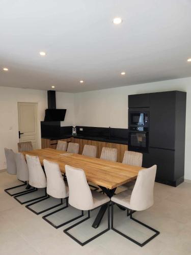 une salle à manger avec une table en bois et des chaises blanches dans l'établissement Maison La Ribièra, à Bourisp