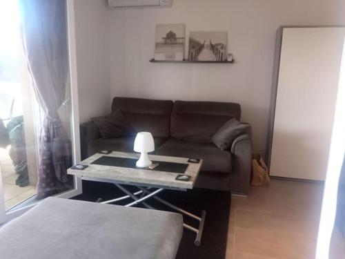 - un salon avec un canapé et une table avec une lampe dans l'établissement studio rez de jardin, à Fréjus