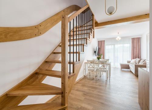 a wooden staircase in a living room with a table at Bieszczadzkie Siedlisko in Polańczyk