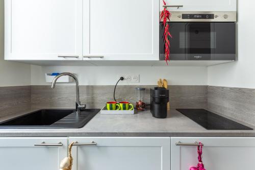 ルヴァロワ・ペレにある2 pièces-Moderne-Proche Parisのシンクと電子レンジ付きのキッチンカウンター