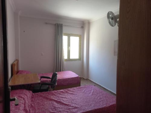 a room with two beds and a table and a chair at Apartment in 6 October city in 6th Of October