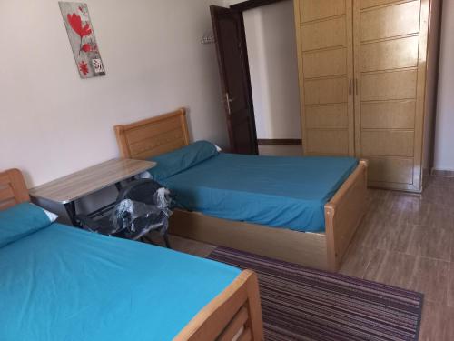 a room with two beds and a table and a door at Apartment in 6 October city in 6th Of October