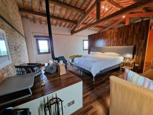 a bedroom with a bed and a table in a room at Casali Marchigiani - Ville vacanza private con piscina in Ostra