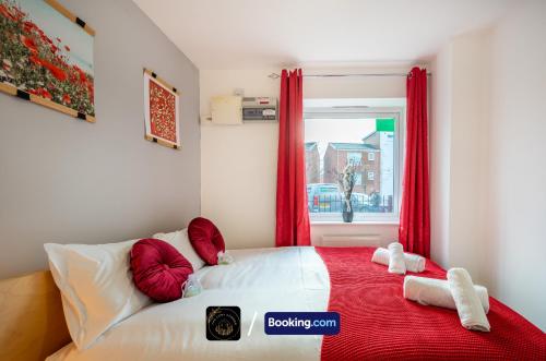 a bedroom with a bed with red curtains and a window at Cosy 4-Bed House l Garden l Free Parking l WiFi l Specious l Hosted by The Cosy Corner Nationwide in Manchester