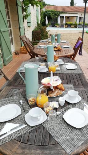 une table en bois avec des assiettes de nourriture dessus dans l'établissement La Vergne, à Saint-Martin-des-Combes