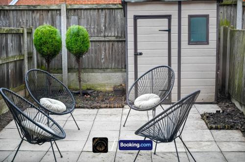 two chairs with pillows sitting on a patio at Cosy 4-Bed House l Garden l Free Parking l WiFi l Specious l Hosted by The Cosy Corner Nationwide in Manchester