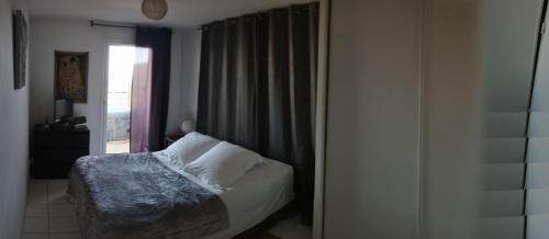 une chambre avec un lit et une fenêtre dans l'établissement Marseille autrement Appartement dans résidence calme avec vue sur mer, à Marseille