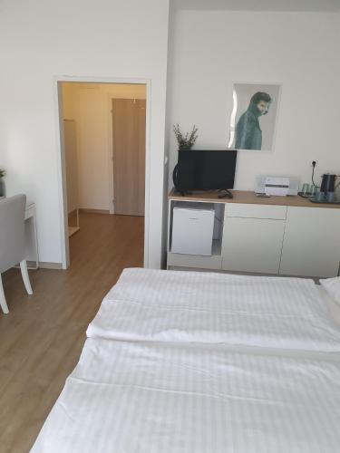 a white bedroom with a bed and a desk at Ubytování Láskomina in Pacov