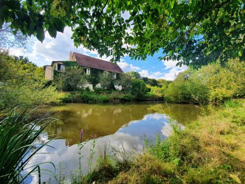 an old house on the side of a river at Ferme équestre & Chambres d'hôtes Gateau Stables proche Guédelon in Saint-Amand-en-Puisaye