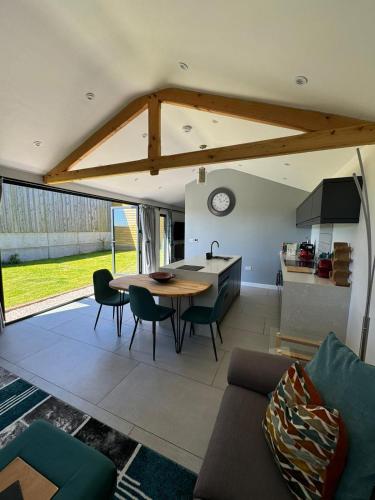 a kitchen and living room with a table and chairs at Lavish Dorset countryside retreat in Bradpole