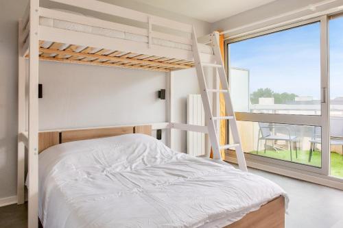 une chambre avec des lits superposés et une fenêtre avec une échelle dans l'établissement Vue mer - À 160m de la plage - Appartement pour 4, à Bénodet
