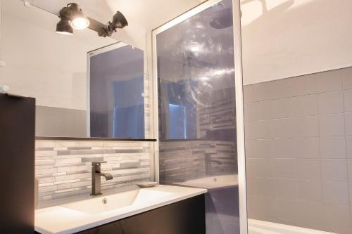 une salle de bain avec un lavabo, un miroir et une baignoire dans l'établissement Vue mer - À 160m de la plage - Appartement pour 4, à Bénodet