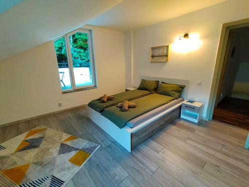 a bedroom with a bed with two stuffed animals on it at Tarnita Summer House in Someşu Cald